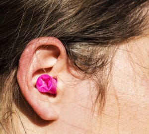 Plugged womans ear for protection.